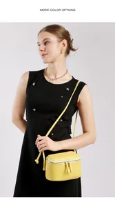 Détail d'un sac bandoulière en cuir jaune vif avec double fermeture éclair élégante