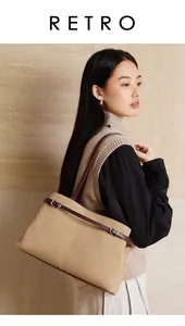 Detail of camel suede tote bag showing brown leather strap and silver metal buckle