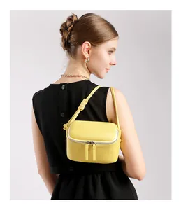Détail du sac à main jaune en cuir grainé avec bandoulière nouée et texture de qualité