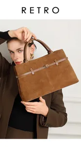 Close-up of brown matte leather tote bag with metallic buckle and retro texture detail
