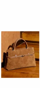 Detail of camel suede tote bag featuring a leather strap with a round metal buckle