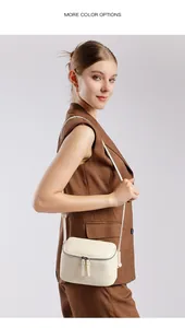 Détail du sac bandoulière en cuir blanc cassé texturé porté par un mannequin