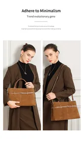 Detail view of brown suede tote bag with decorative straps and metal pin buckles