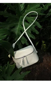 Détail du sac à bandoulière blanc en cuir grainé avec design unique de bandoulière nouée