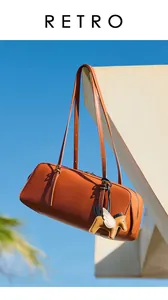 Detalle de bolso cilíndrico de cuero marrón con colgante de caballo y fondo de cielo
