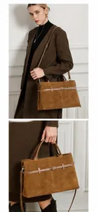 Detailed view of brown suede tote bag with leather straps and metallic buckle accents