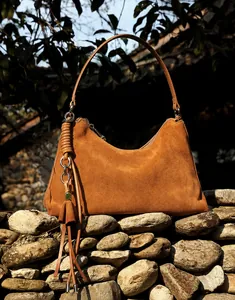 Detailaufnahme der braunen Wildleder-Hobo-Tasche mit geknotetem Gurt und Fransen-Dekor