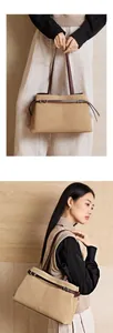 Detail of khaki frosted tote bag with dark brown leather straps and metallic buckle