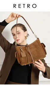 Dettaglio borsa tote in pelle scamosciata marrone con tasche laterali e fibbie dorate