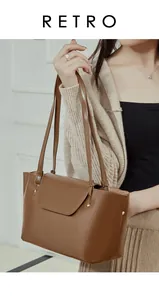 Close-up of retro brown leather shoulder bag with vintage gold studs and slim straps