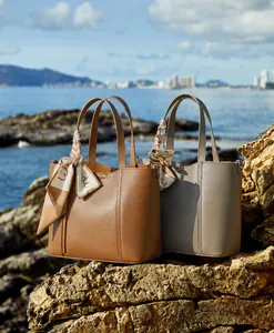 Detalle de un bolso tote de piel granulada con elegante pañuelo de seda decorativo