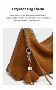 Makroaufnahme von Silberring mit Lederknoten und Quasten an brauner Wildledertasche