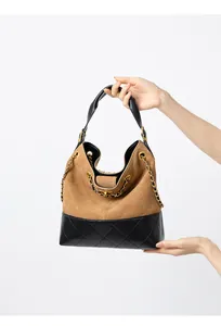 Dettaglio della borsa hobo trapuntata in camoscio e pelle con catena dorata elegante