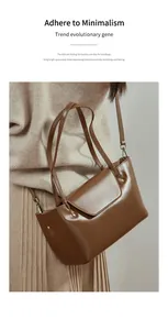Brown polished leather shoulder bag styled with beige knitwear and pleated skirt