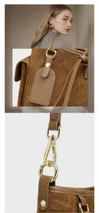 Dettaglio della borsa tote in pelle scamosciata marrone con fibbie dorate e tracolla
