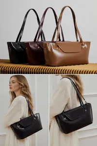 Detail of adjustable leather straps for versatile tote bag in black, burgundy, and camel