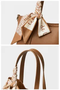 Primer plano de la textura de cuero genuino y el elegante pañuelo de seda en el bolso marrón