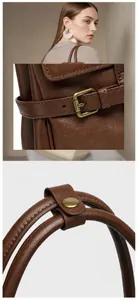 Dettaglio dell'hardware in metallo vintage antiossidante e fibbia regolabile sulla borsa in pelle