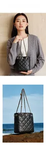 Detail showing black quilted bucket bag with gold floral clasp and leather chain strap
