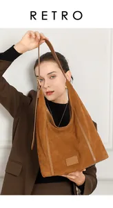 Sac hobo en daim marron avec bandoulière réglable porté par un mannequin en style rétro