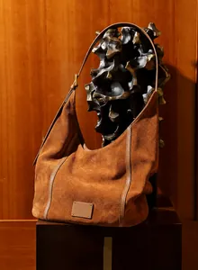 Détail du sac hobo en daim marron avec bandoulière réglable et grand compartiment