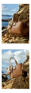 Detalle de bolso tote de piel marrón con pañuelo de seda decorativo sobre rocas