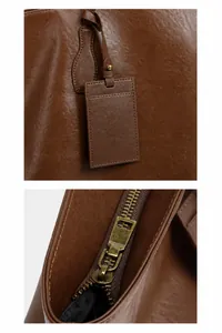 Close-up of vintage metal zipper and leather tag on brown genuine cowhide tote bag