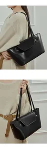 Detailed view of black leather tote bag with flap and metal rivets for commuter use