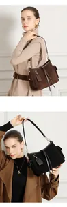 Dettaglio di grandi borse tote in pelle opaca marrone scuro e nero con tasche laterali