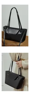 Detail view of black veg-tan leather tote with metal studs and flap closure design