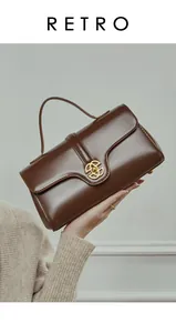 Close-up of retro brown leather handbag featuring a unique gold interlocking metal clasp