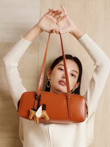 Bolso Boston de cuero curtido vegetal marrón con colgante de pegaso y correas