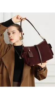 Dettaglio della borsa tote in pelle scamosciata rossa con hardware dorato e tasca