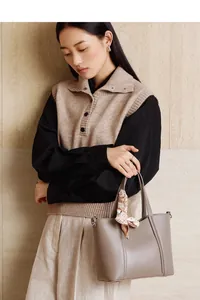 Detalle del bolso tipo cubo de cuero topo con pañuelo decorativo y ganchos metálicos en D
