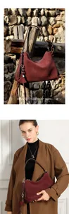 Detail der burgunderroten Wildleder-Hobo-Tasche mit Quasten und Ledergriff-Details