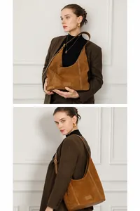 Détail d'un sac hobo en cuir mat marron montrant la bandoulière réglable et le daim