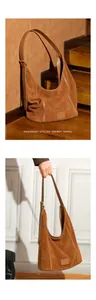 Détail du sac hobo en daim marron avec bandoulière réglable et boucle dorée élégante