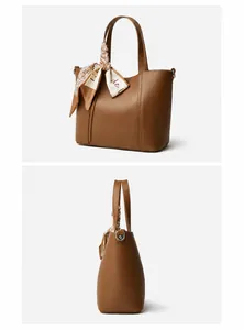 Detalle de bolso tote de cuero marrón con pañuelo decorativo y anillos en D laterales