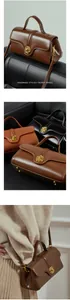 Detail of genuine leather handbag featuring a vintage gold metal buckle and smooth texture