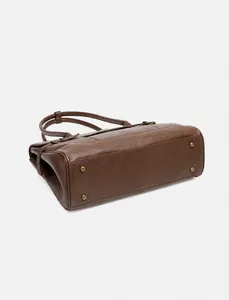 Dettaglio del fondo della borsa tote in pelle con quattro piedini in ottone