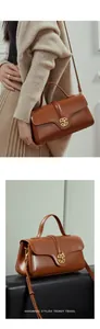 Detail of vintage leather handbag with a round flap and elegant golden metal twist lock