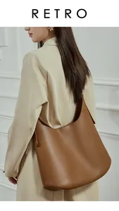 Close-up of retro minimalist dark brown leather tote bag worn by model on shoulder