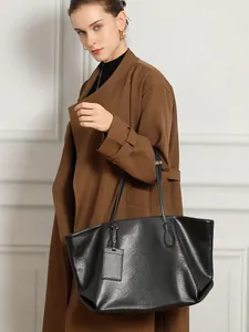Large black vegetable tanned leather tote bag styled with a premium trench coat look