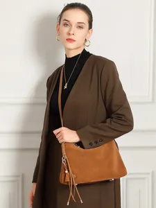 Braune Vintage-Tasche aus mattem Rindsleder mit Quasten-Anhänger, getragen zum Mantel
