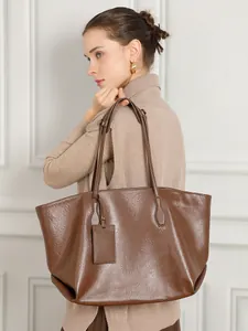 Large coffee brown vegetable-tanned leather tote bag shown on model with shoulder strap