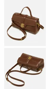 Detailed views of brown leather handbag with gold metal clasp from side and top angles