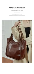 Détail d'un sac cabas en cuir marron foncé minimaliste porté par un mannequin en intérieur