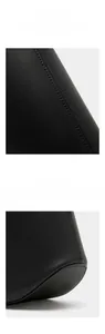 Detail view of reinforced stitching and curved bottom design on a black leather handbag