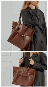 Brown leather tote bag featuring sleek shoulder straps and an elegant metal buckle detail