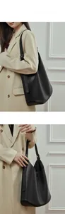 Minimalist black leather bucket bag shown on model for daily commuting style